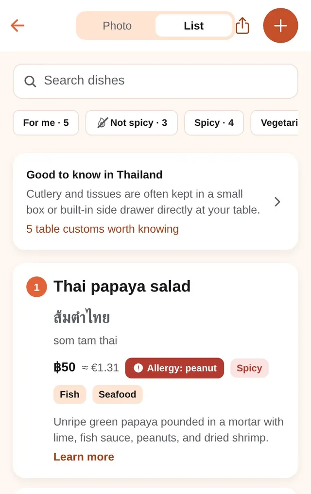 The List view, with the Photo | List switch at the top, search and filters; then Thai papaya salad (ส้มตำไทย, som tam thai), 50 baht, about €1.31, tags “Allergy: peanut”, “Spicy”, “Fish”, “Seafood”; then Pad Thai with fresh prawns.